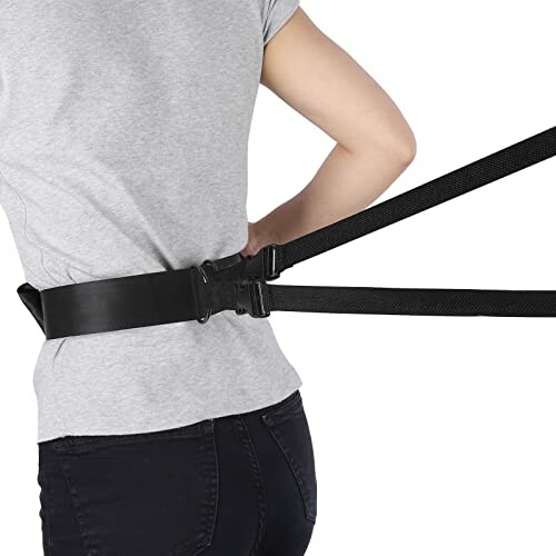 Person wearing a black belt with attached straps for support.