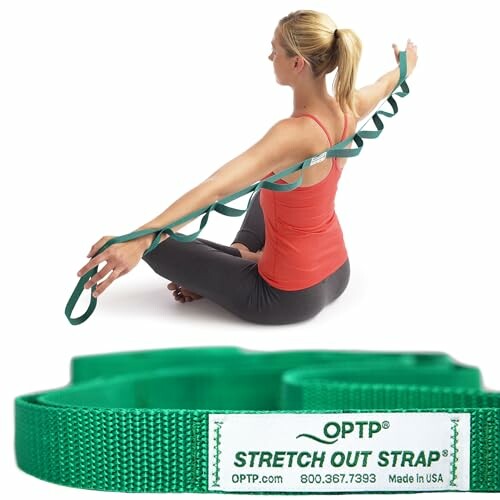 Woman using a green stretch out strap for exercise.